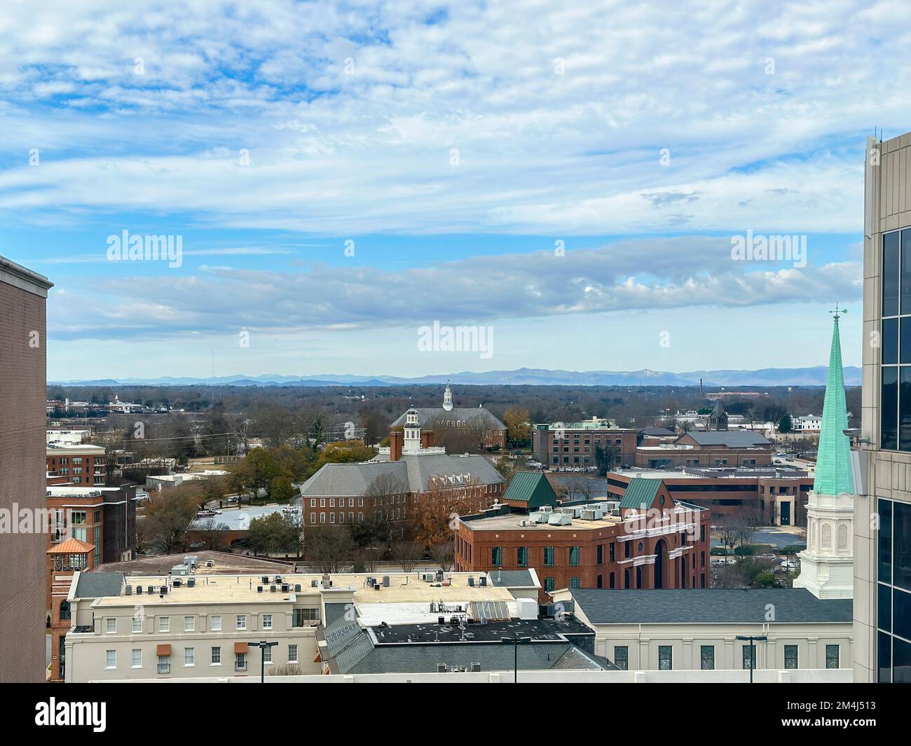 Looking over downtown Greenville, South Carolina from an upper floor with Blue Ridge Mountains in the distance. Stock Photo