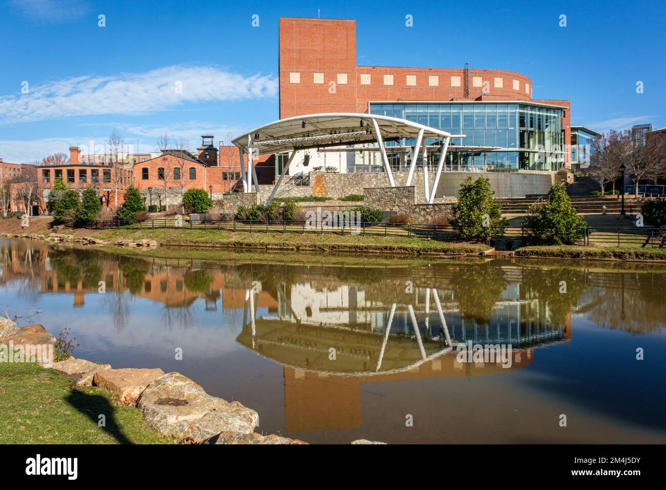 The Peace Center is reflected in the water of the Reedy River in downtown Greenville, South Carolina. Stock Photo