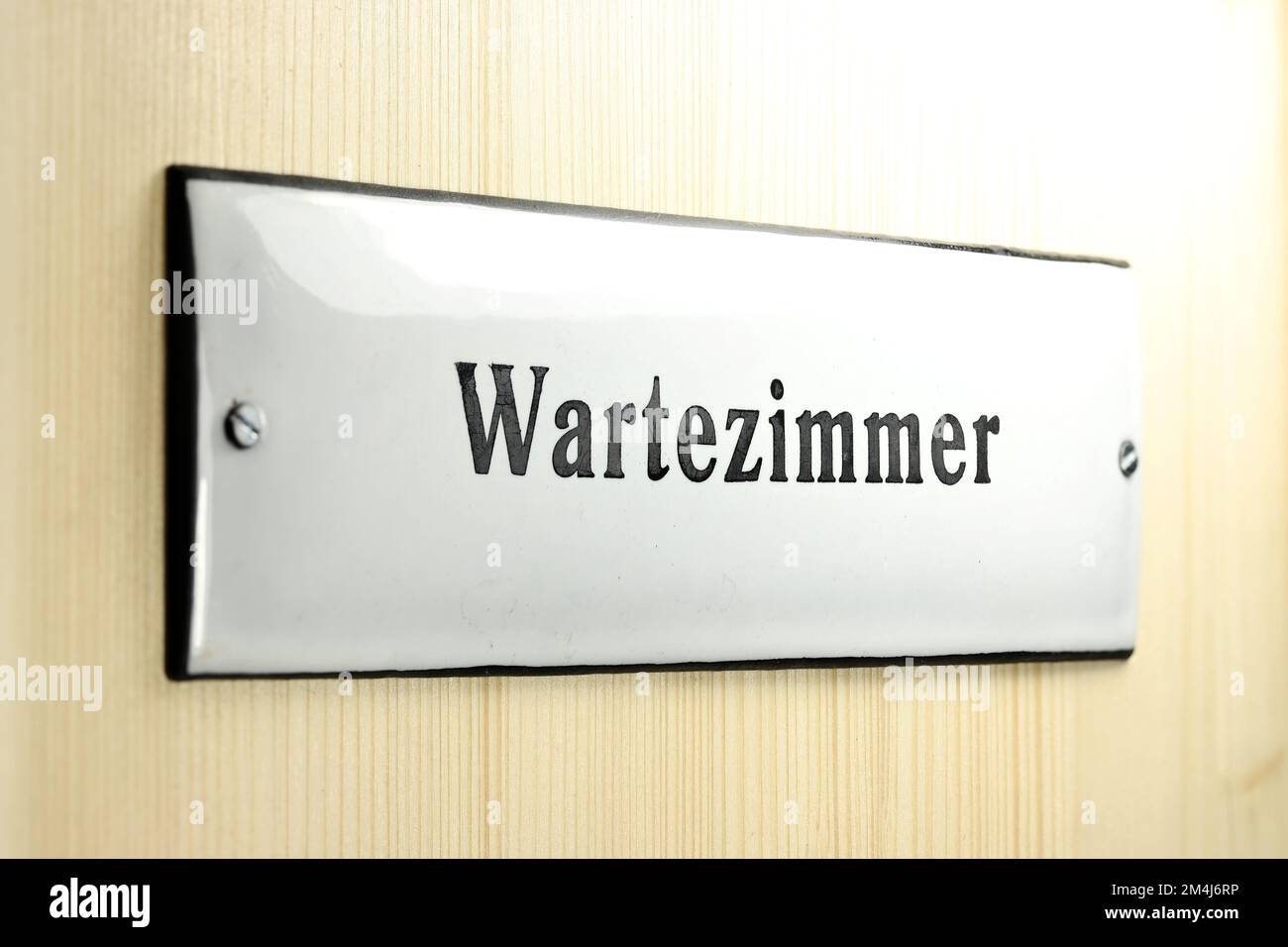 enamel sign on the door to the waiting room of a German doctor's office Stock Photo