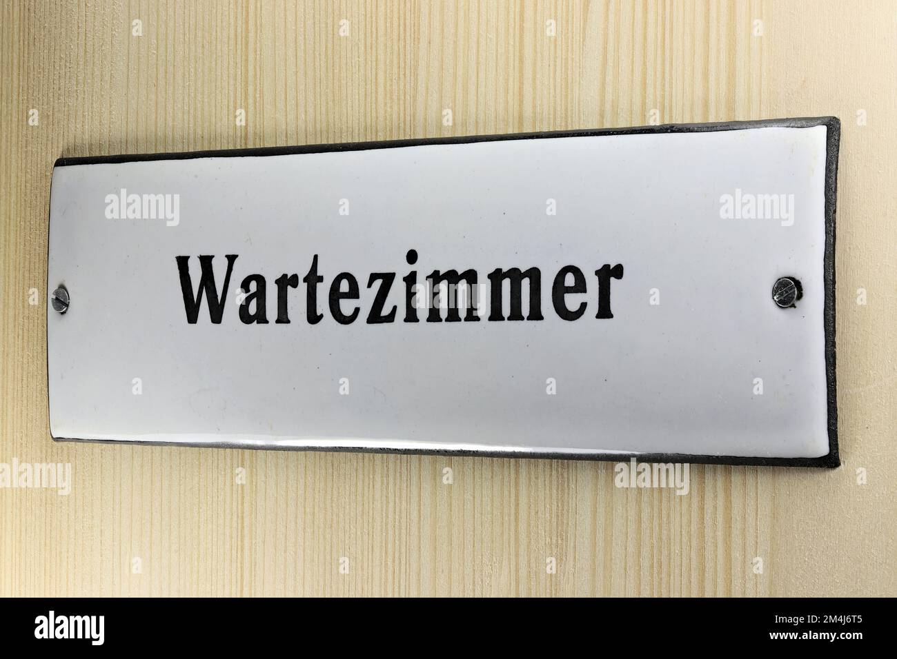 enamel sign on the door to the waiting room of a German doctor's office Stock Photo
