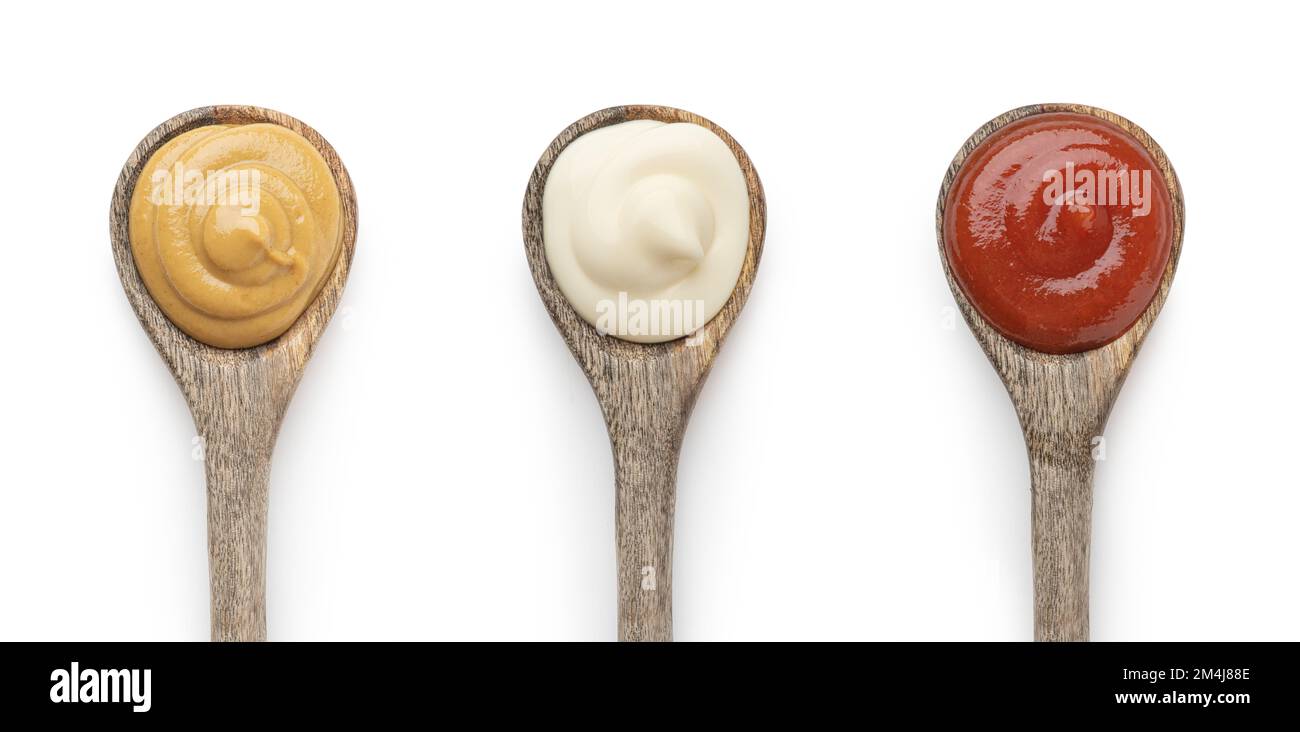 A set of sauces in wooden spoons on a white background Stock Photo