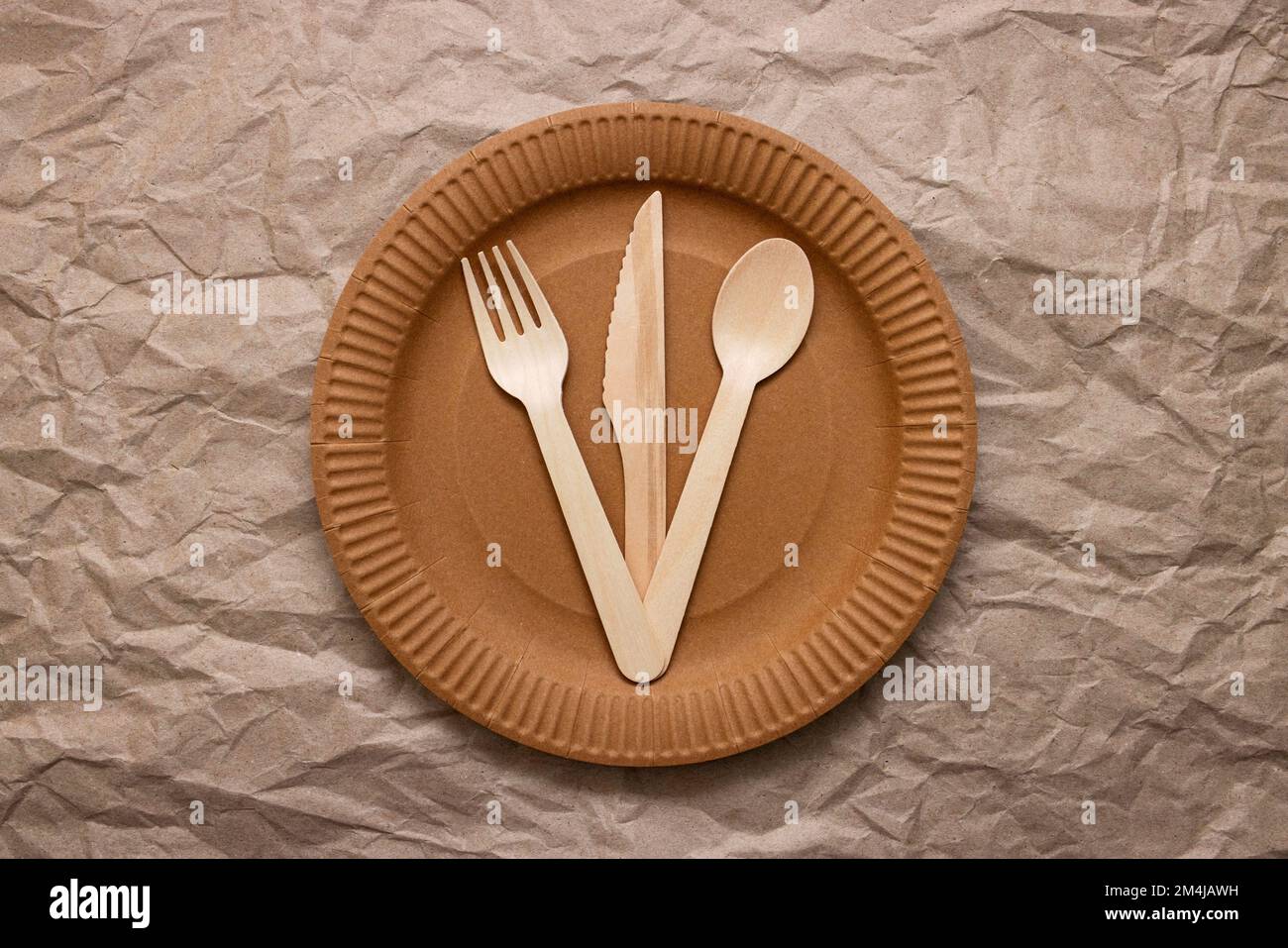 https://c8.alamy.com/comp/2M4JAWH/wooden-fork-spoon-and-knife-on-cardboard-plate-on-crumpled-paper-2M4JAWH.jpg