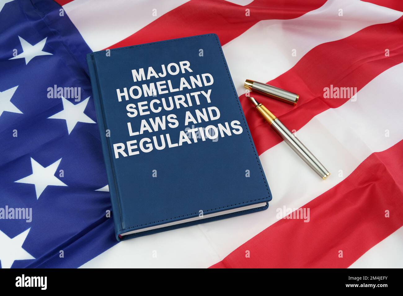 Law concept. On the US flag lies a pen and a book with the inscription - MAJOR HOMELAND SECURITY LAWS AND REGULATIONS Stock Photo