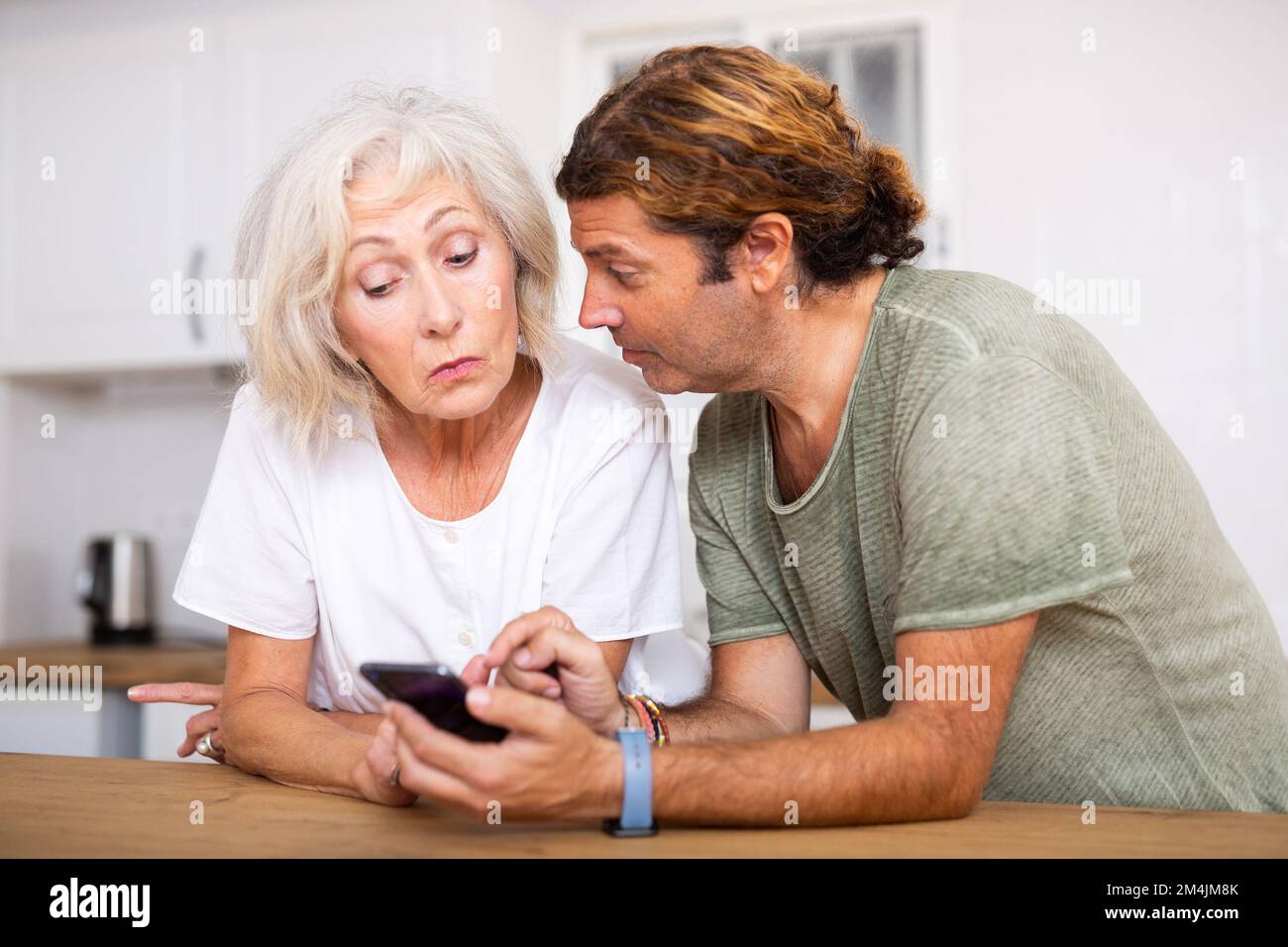 Relaxed mature couple using phone at home Stock Photo