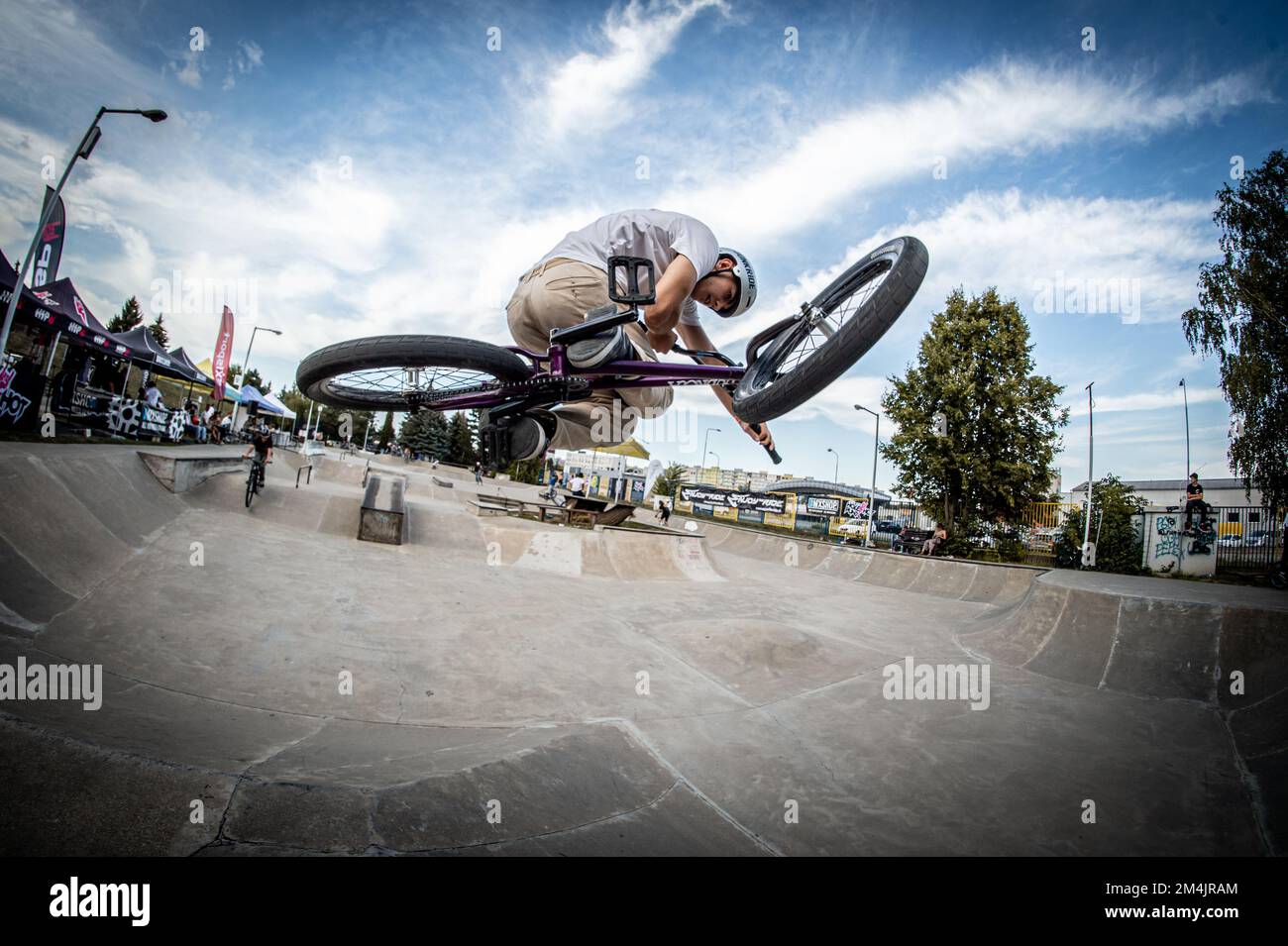 A young man jumping on a bike during the BMX race event in Skate park ...