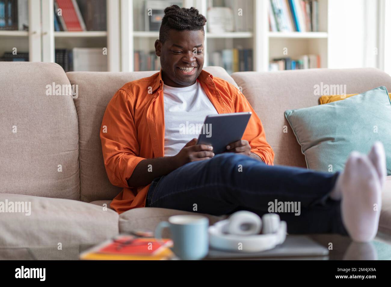 Smiling african american guy using digital pad at home Stock Photo