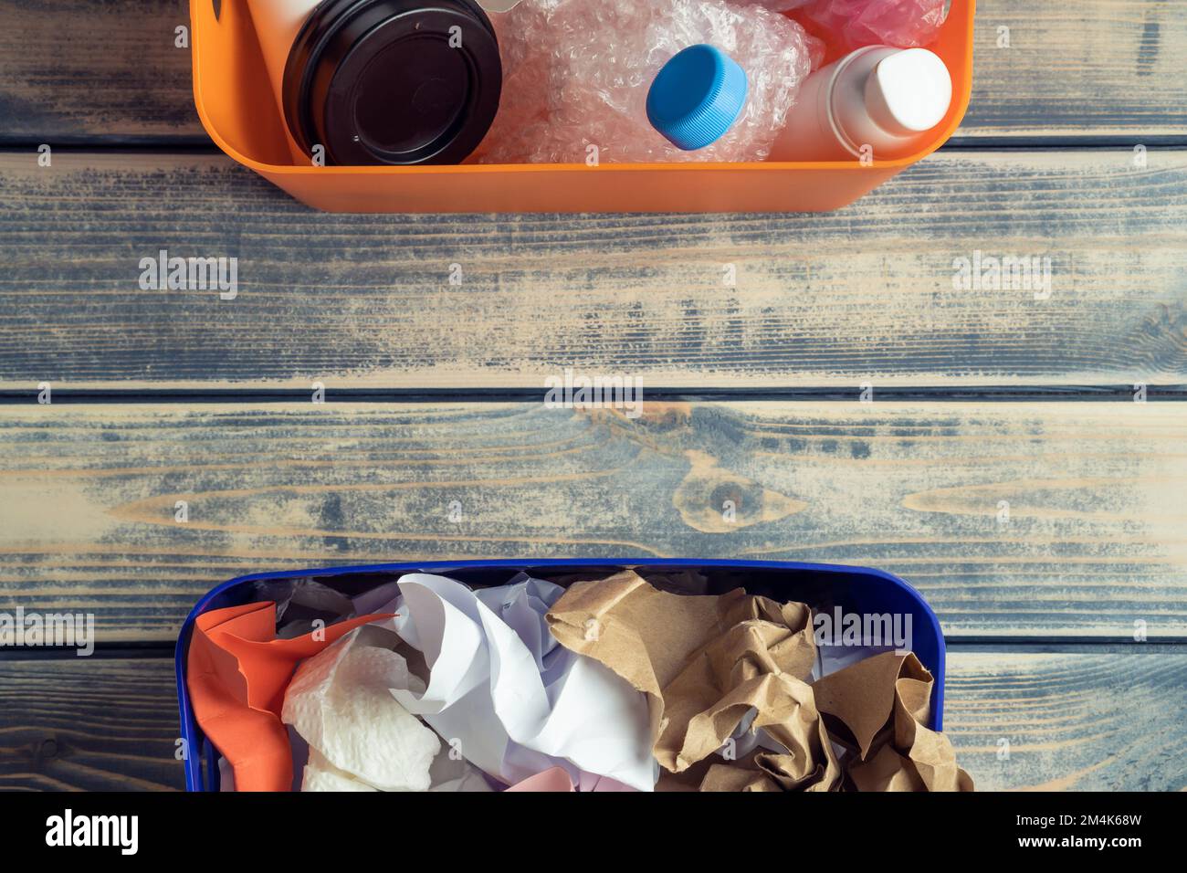 Two halves colorful containers with plastic and paper waste, trash on