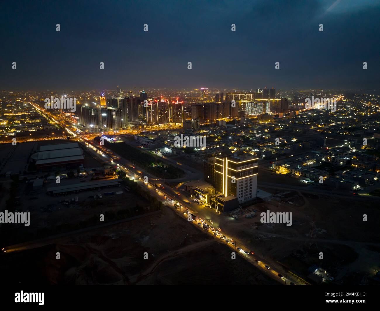 An aerial view of Erbil city with busy streets and illuminated skyscrapers at night, Iraq Stock Photo