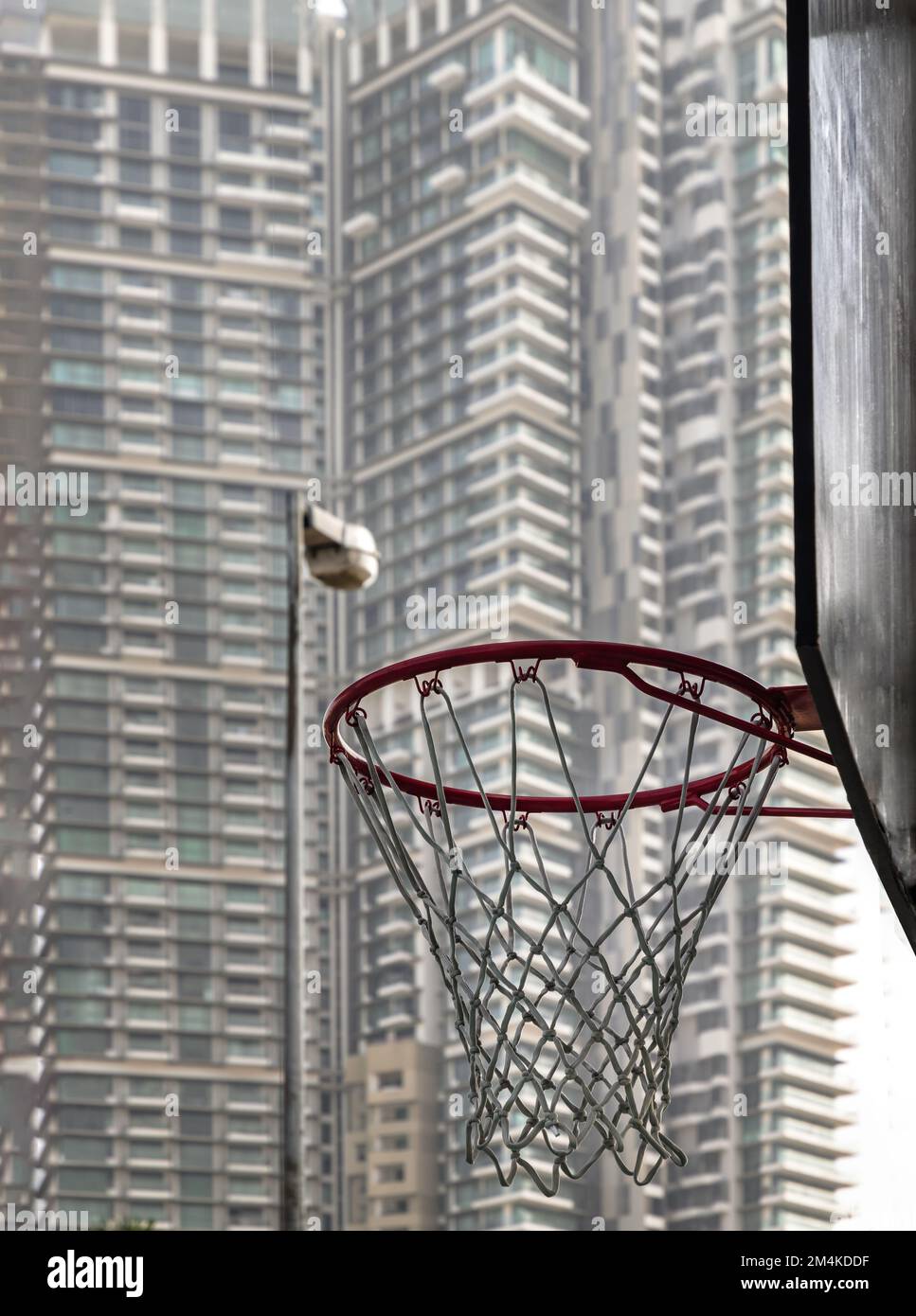 Side view of orange metal ring basketball hoop and white net at outdoor