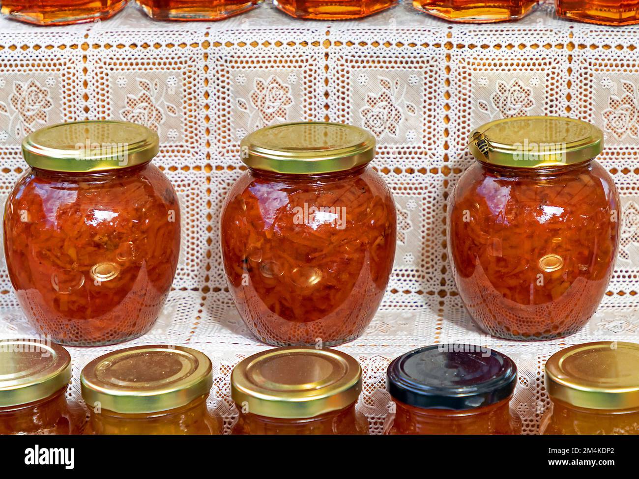 Pickled red vegetables in glass jars on market shelf Stock Photo