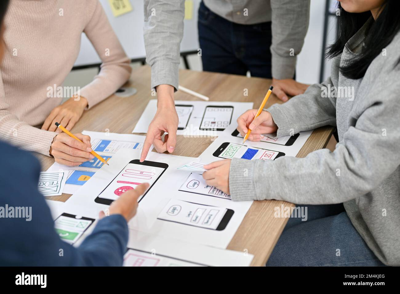 Group of millennial Asian mobile application developers startup are in the meeting, discussing and brainstorming on their new project, testing new pro Stock Photo