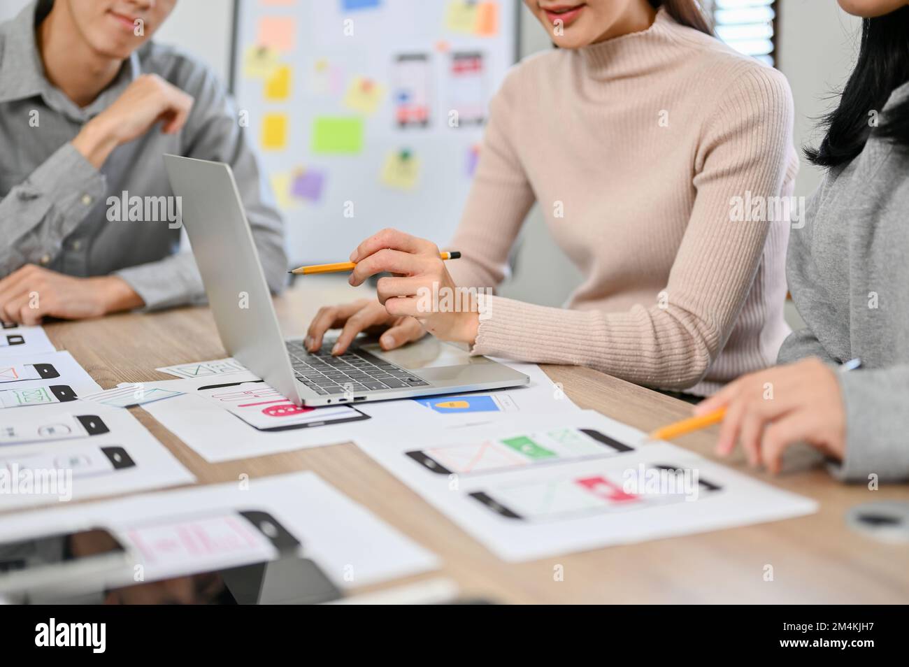 A team of professional millennial Asian website and mobile app developers are in the meeting. cropped image Stock Photo