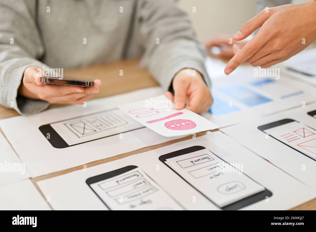 A team of mobile application interface designers are in the meeting, planning and designing their application for their target user. cropped image Stock Photo