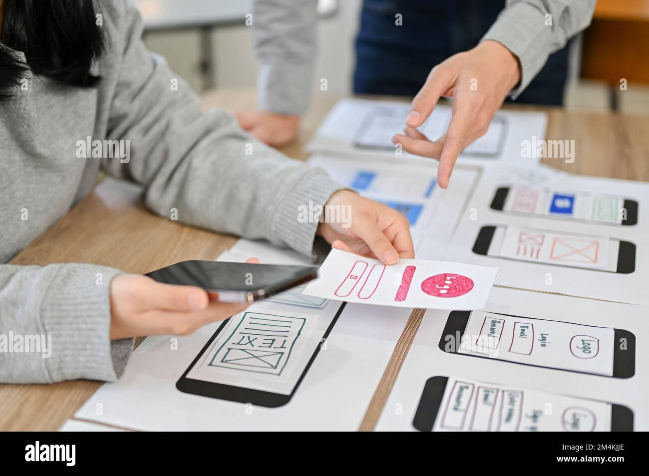 cropped image, A team of mobile application interface designers are in the meeting, planning and designing their application. Stock Photo