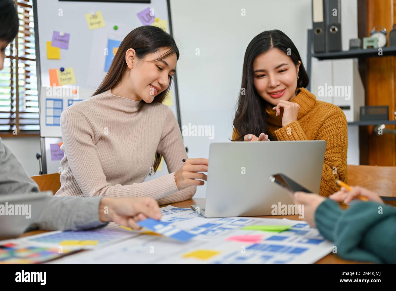 A professional female graphic designer discussing and brainstorming a new prototype with her team. testing and iteration, analysis and development, UX Stock Photo