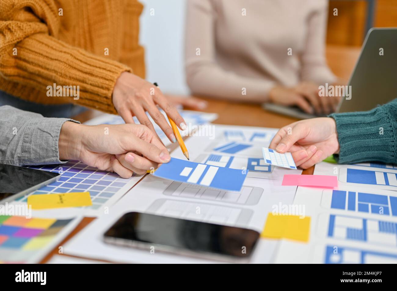 A team of professional mobile application designers are in the meeting, discussing and brainstorming user interface design. close-up image. UX UI conc Stock Photo