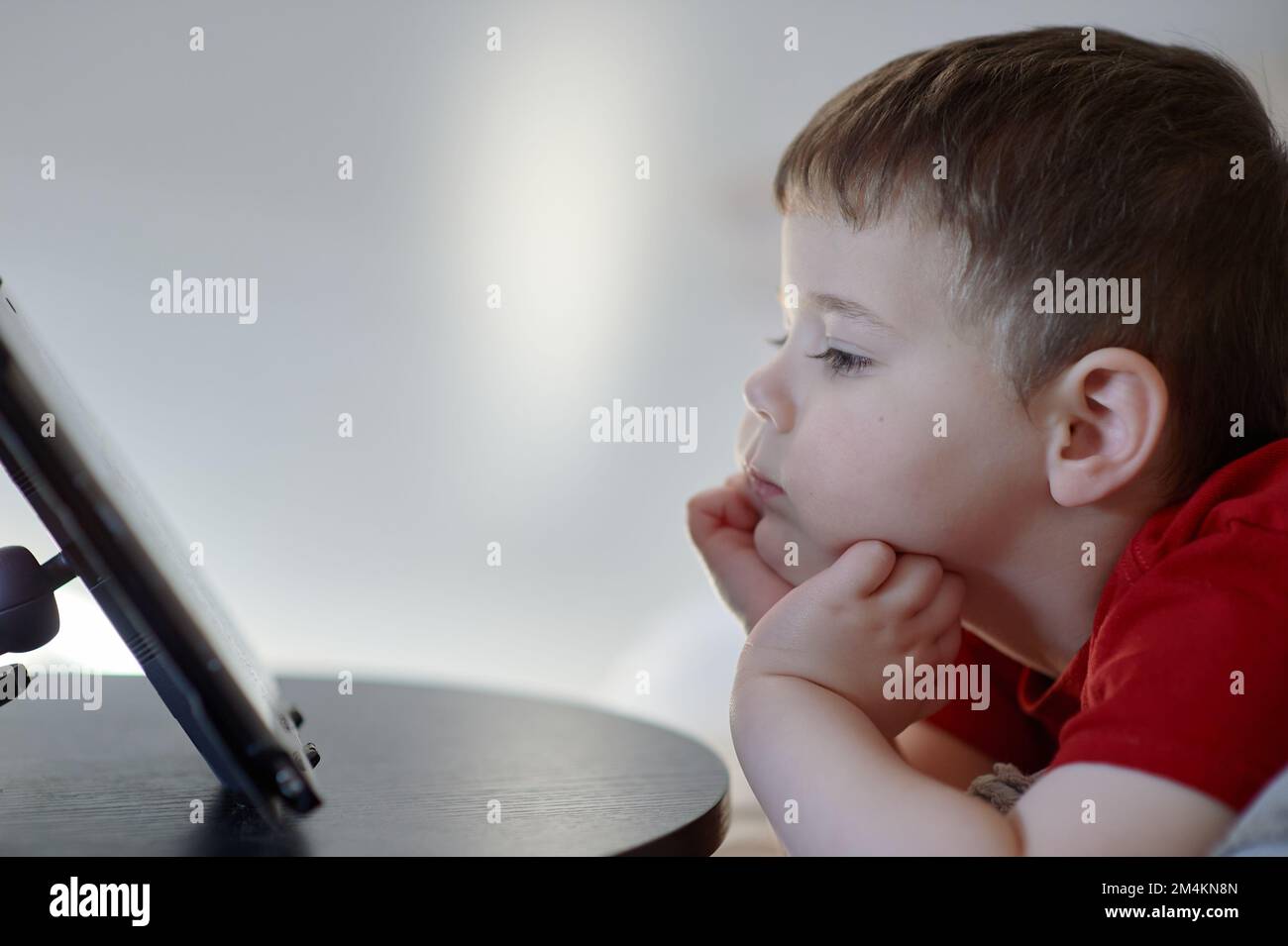 beautiful boy watching cartoons on a table top tablet Stock Photo