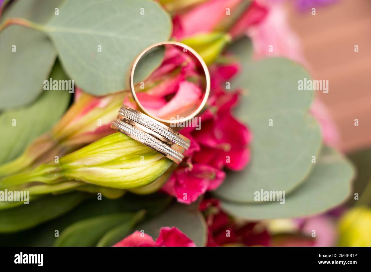 wedding gold rings of the bride and groom lie on the background of a bouquet of flowers of the bride, gold rings at the wedding Stock Photo