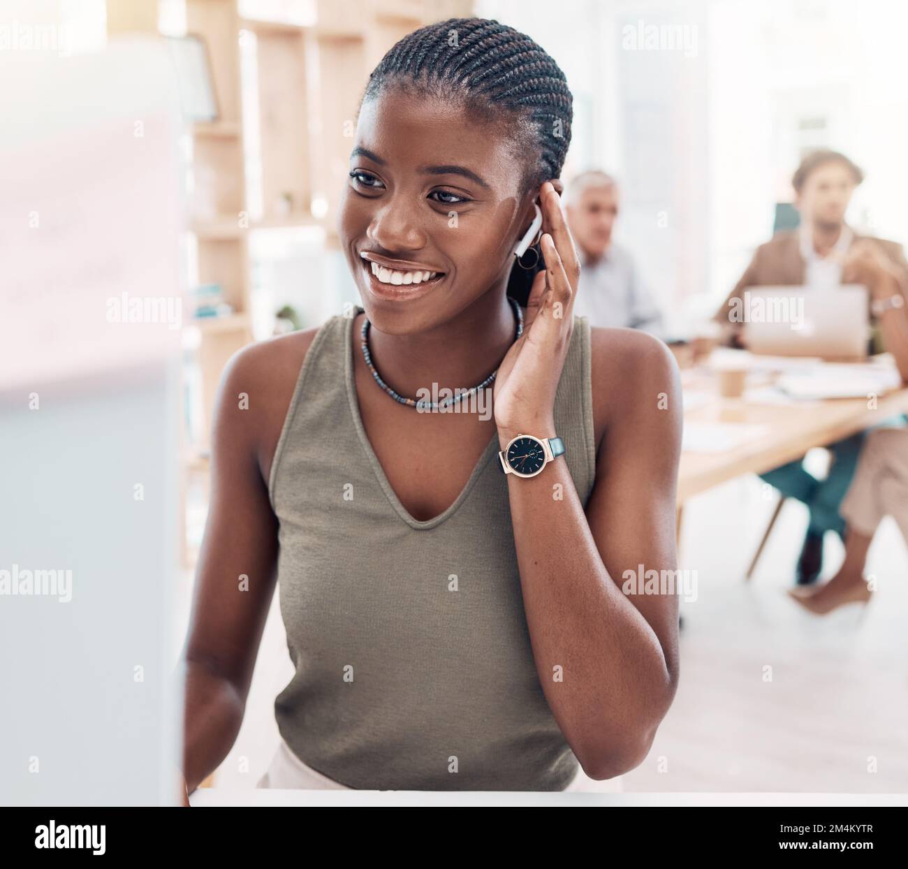 Music, podcast and woman at computer with earphones in office with streaming service while working. Work, smile and happy black woman listening to Stock Photo