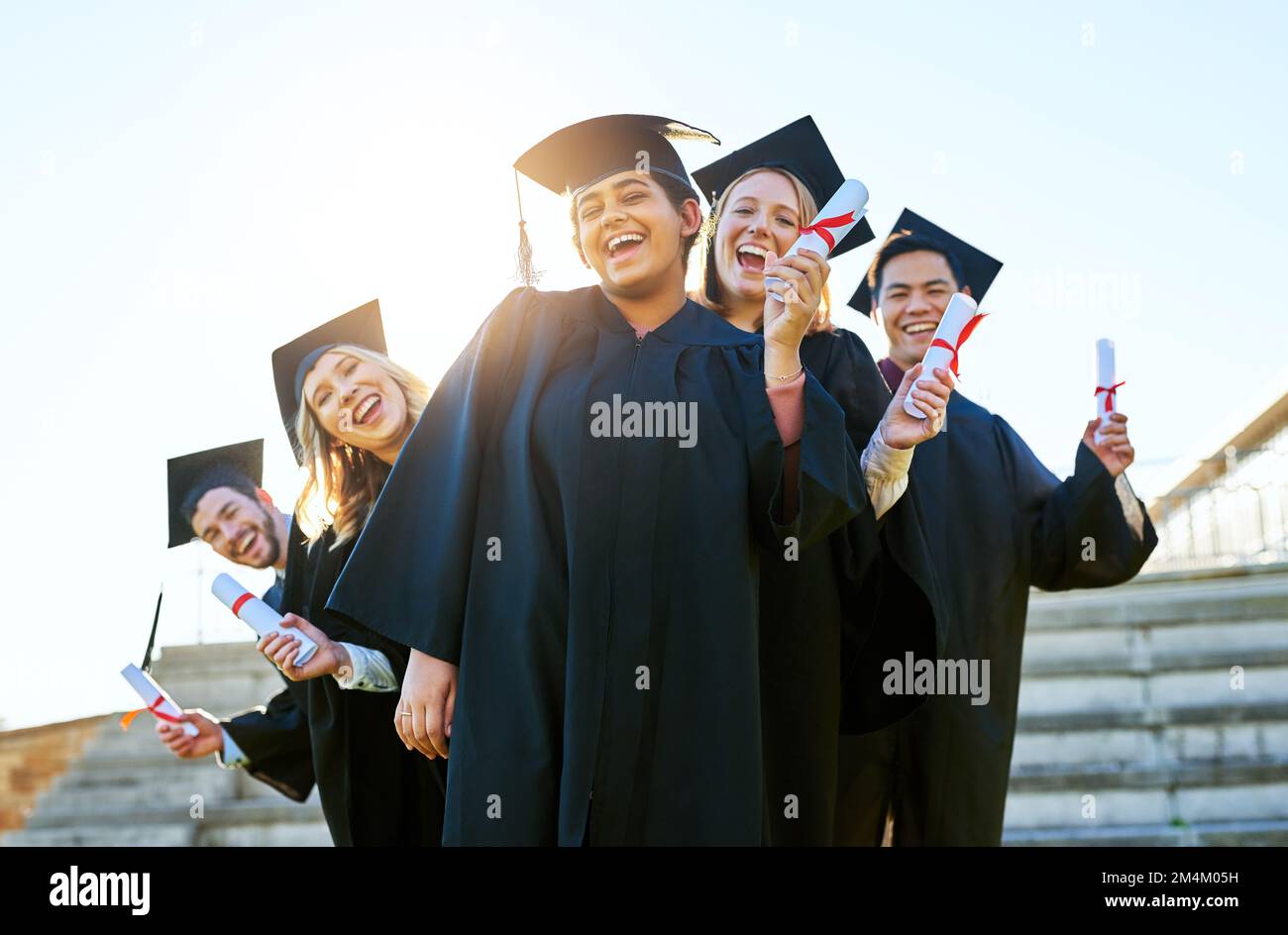 Ready for the real world. Portrait of a group of students holding their diplomas on graduation day. Stock Photo