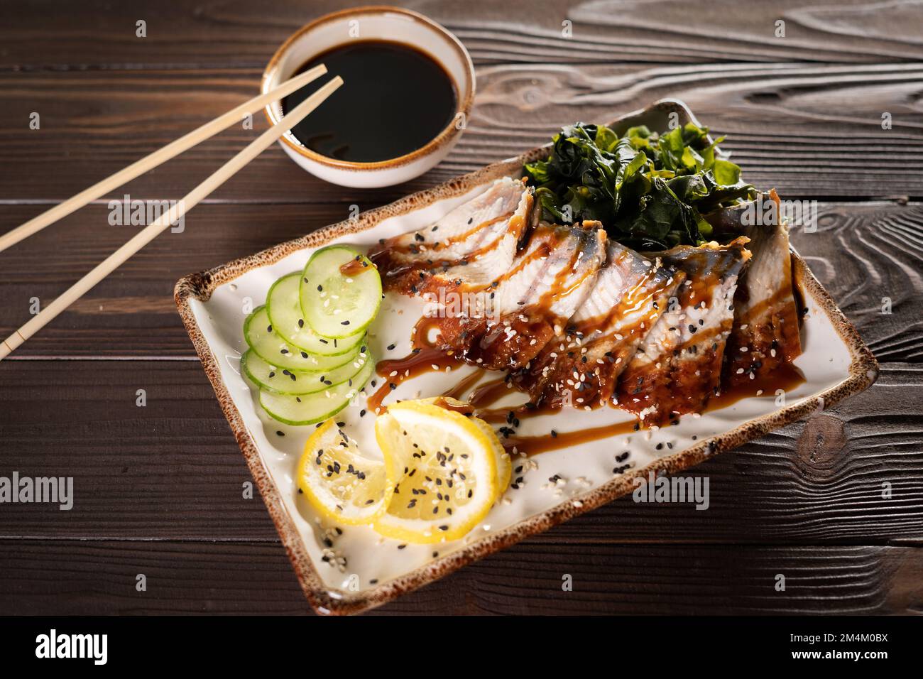 Eel sashimi with cucumber and lemon on a wooden background. Asian cuisine concept Stock Photo