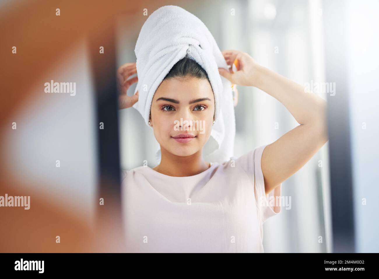 Lets get this fresh day started. a beautiful young woman admiring her skin in the mirror at home. Stock Photo