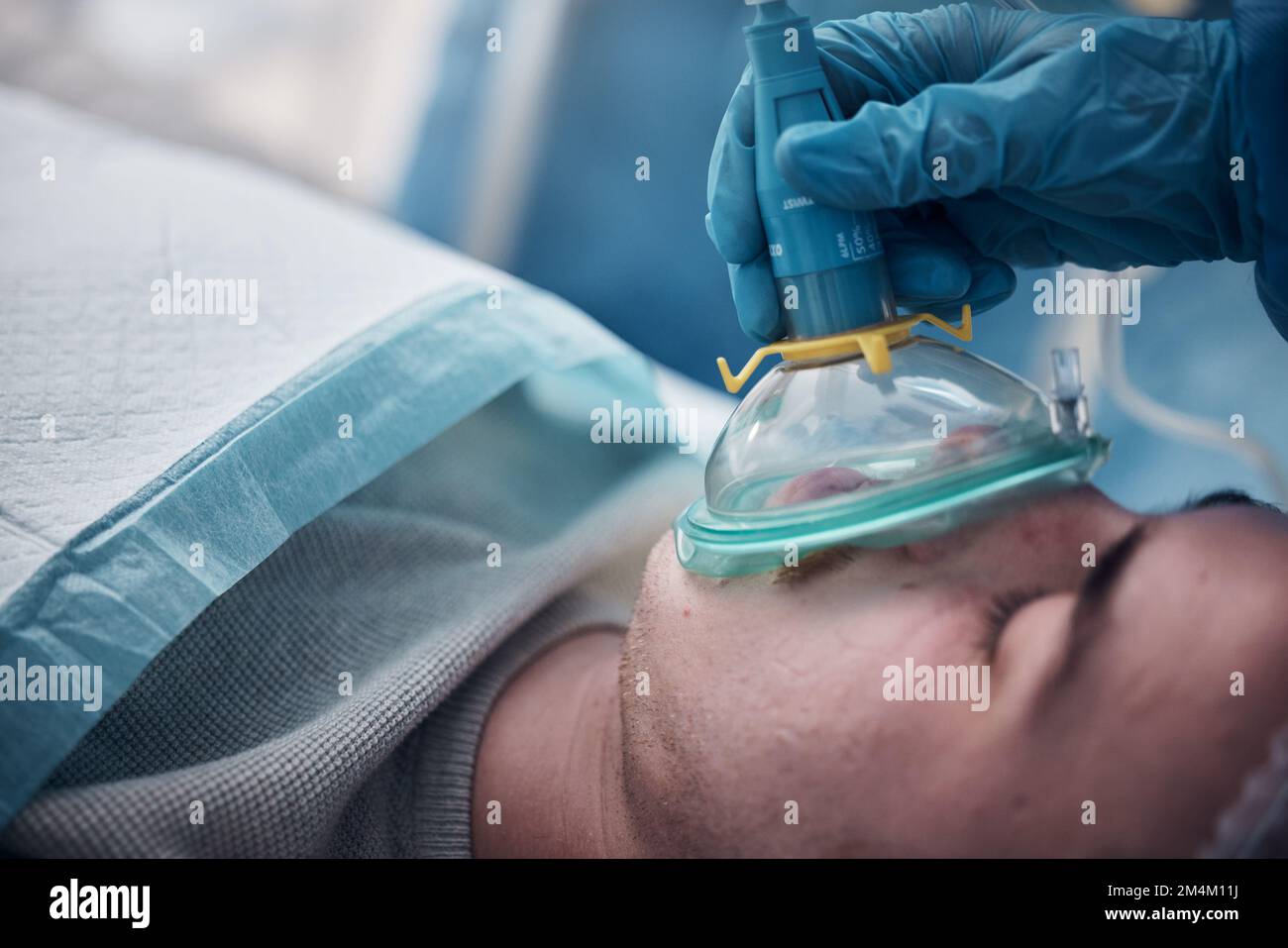 Anesthesia, oxygen mask and medical with man in surgery for breathing, ventilation and operation. Healthcare, cardiology and paramedic with face of Stock Photo