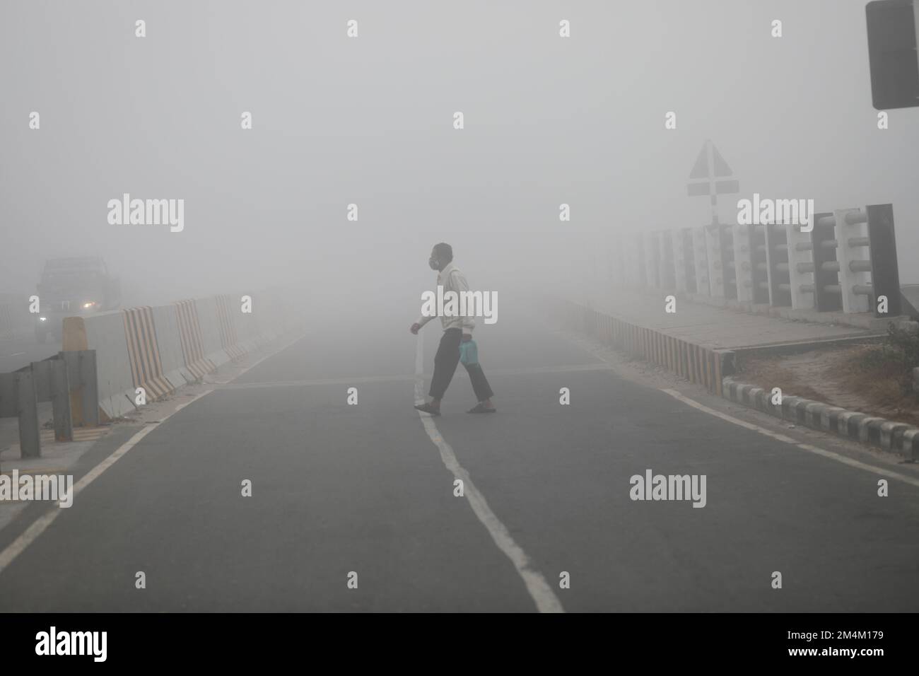 People go to their workplace in a foggy winter morning in Munshiganoj ...