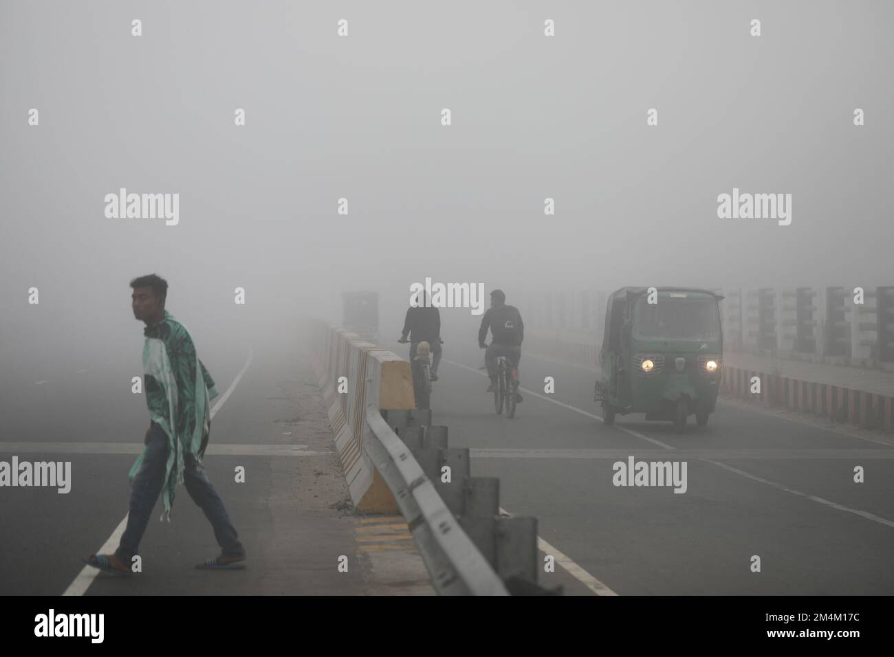 People go to their workplace in a foggy winter morning in Munshiganoj ...
