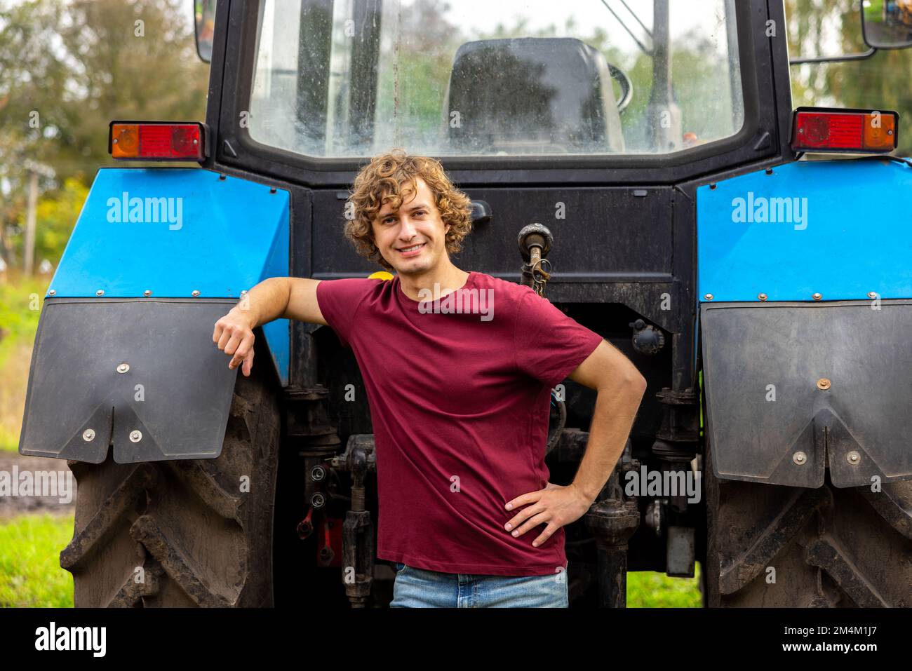 Cheerful tractor driver posing for the camera outside Stock Photo