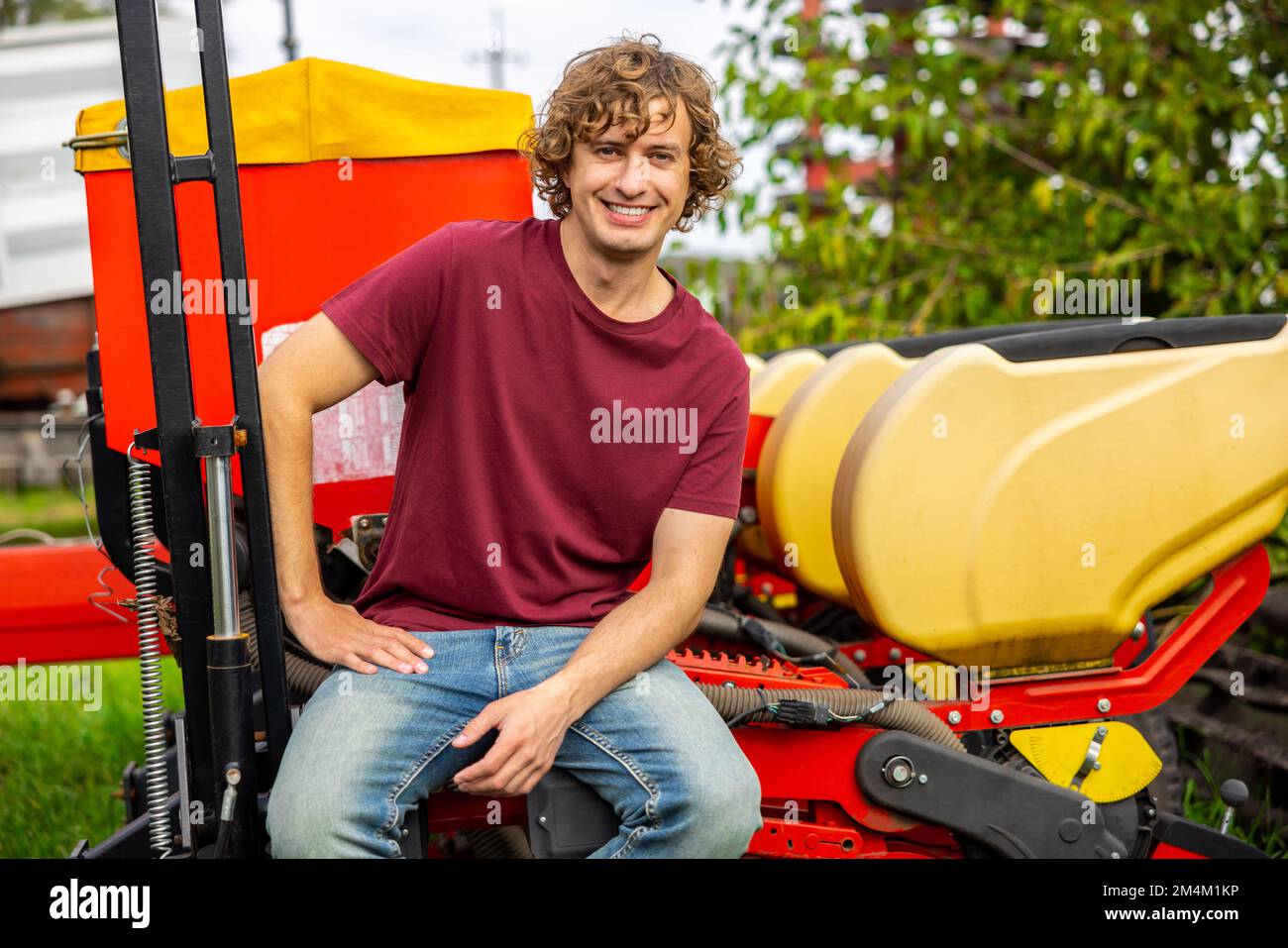 Cheerful farmer sitting on the threshing machine Stock Photo - Alamy