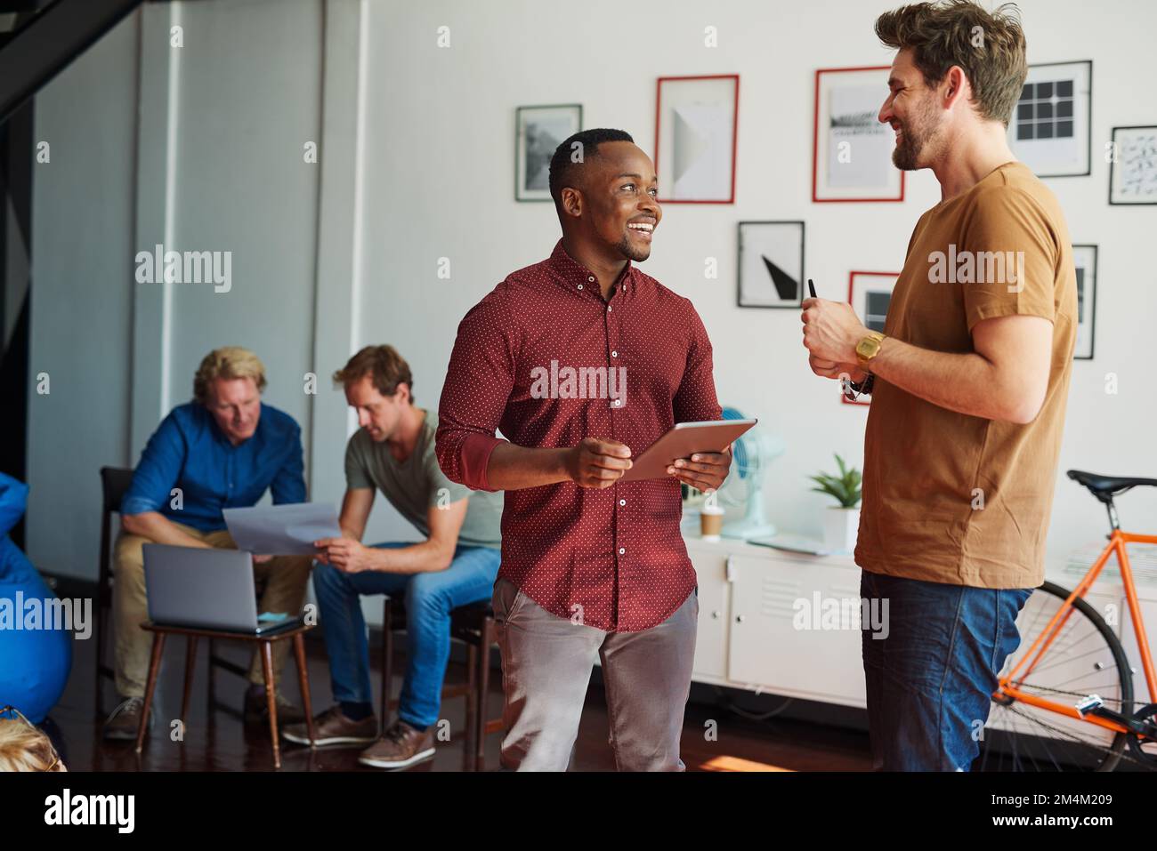 Collaboration is the secret to great ideas. two designers discussing something in an office. Stock Photo