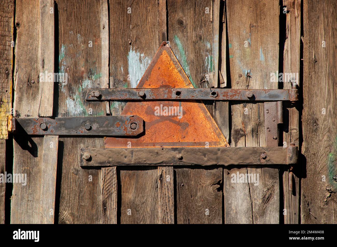 iron sign with skull and bones warning of danger on wooden old door as background Stock Photo