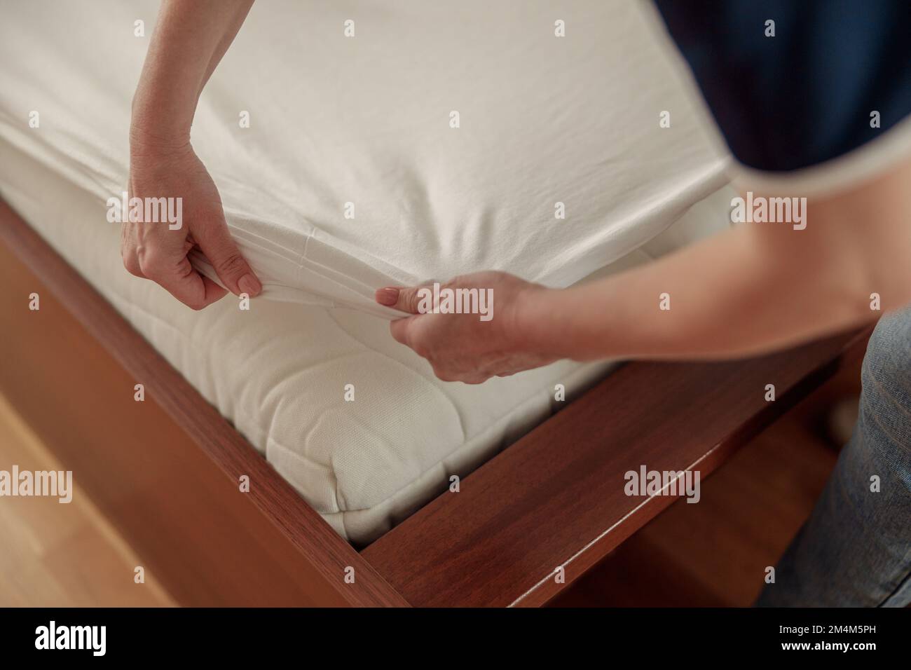 Close up of cleaning lady doing housekeeping and making bed in hotel