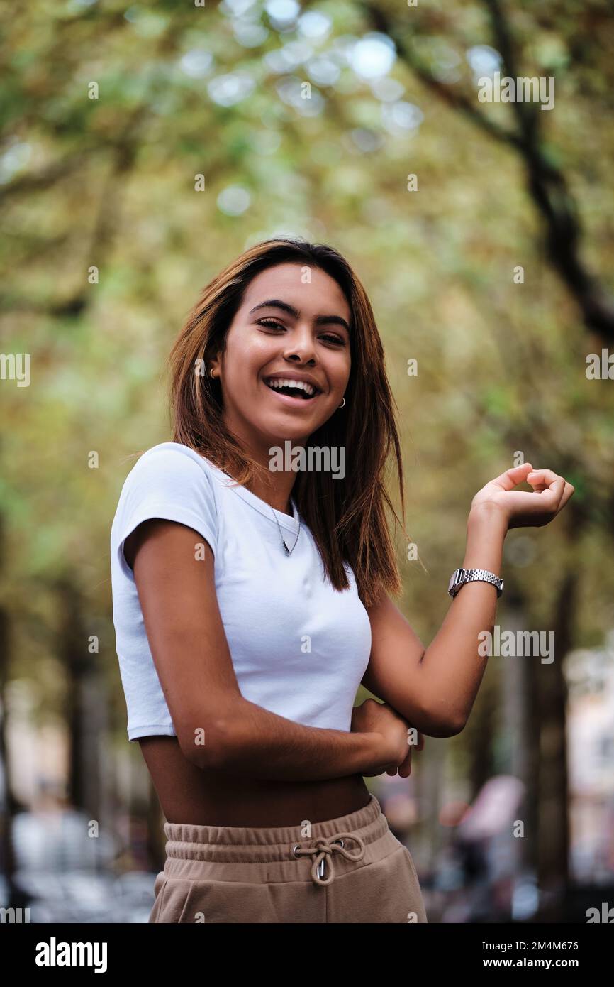 Woman looking at camera and smiling while posing outdoors. Stock Photo