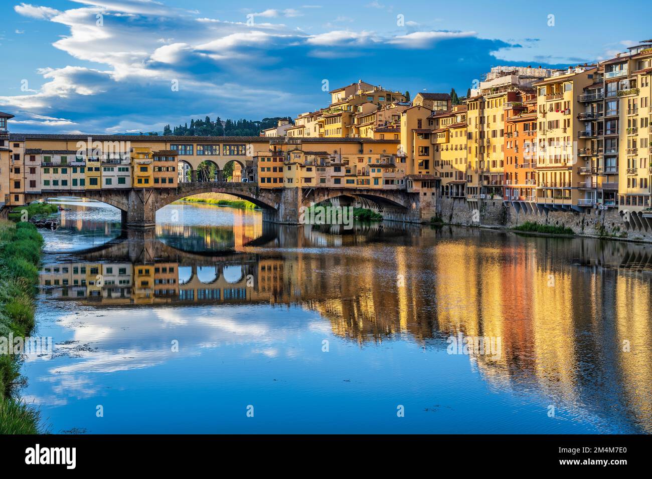 Colourful reflections of Ponte Vecchio and buildings on the south bank of the Arno at sunrise in Florence, Tuscany, Italy Stock Photo