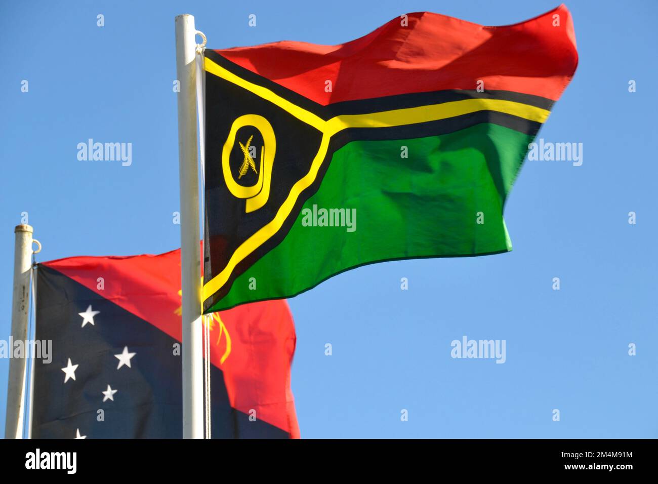 Flags of neighbor islands Vanuatu and Papua New Guinea  in the  Melanesian region of the South Pacific flying together show solidarity and partnership Stock Photo
