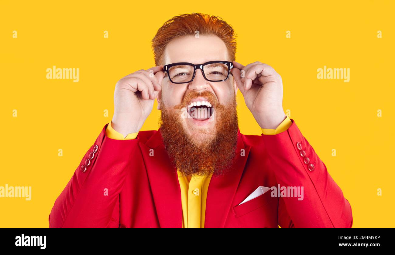 Funny eccentric bearded fat man wearing eyeglasses laughing out loud on orange background. Stock Photo
