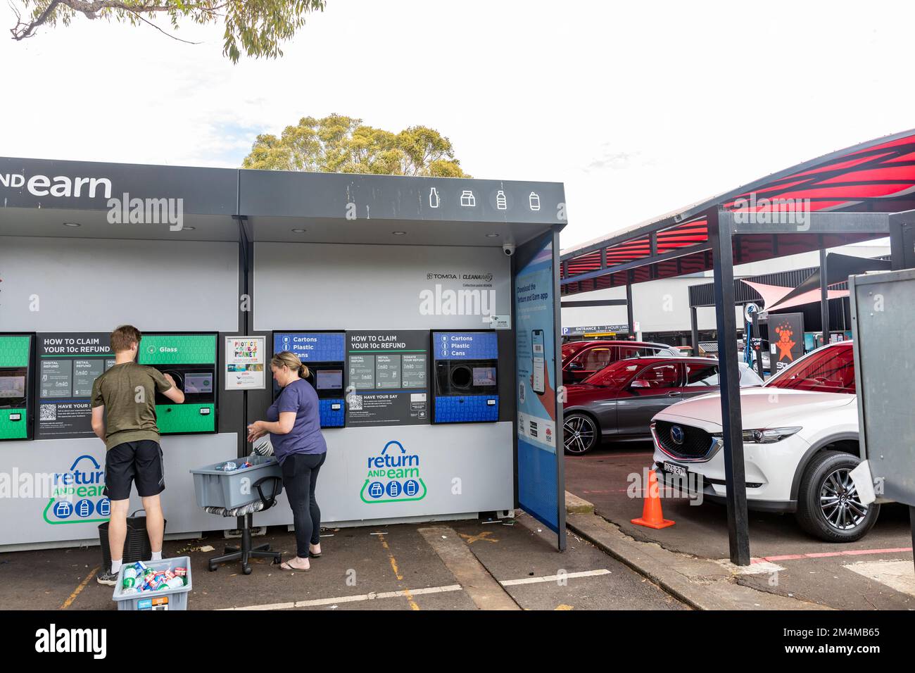 Mother and son recycling bottles and cans at NSW Return and Earn