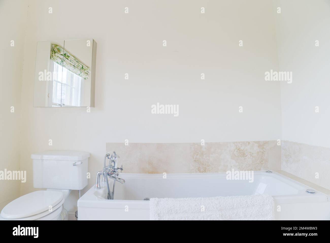 Simple bathroom with bath and toilet typical British residential or
