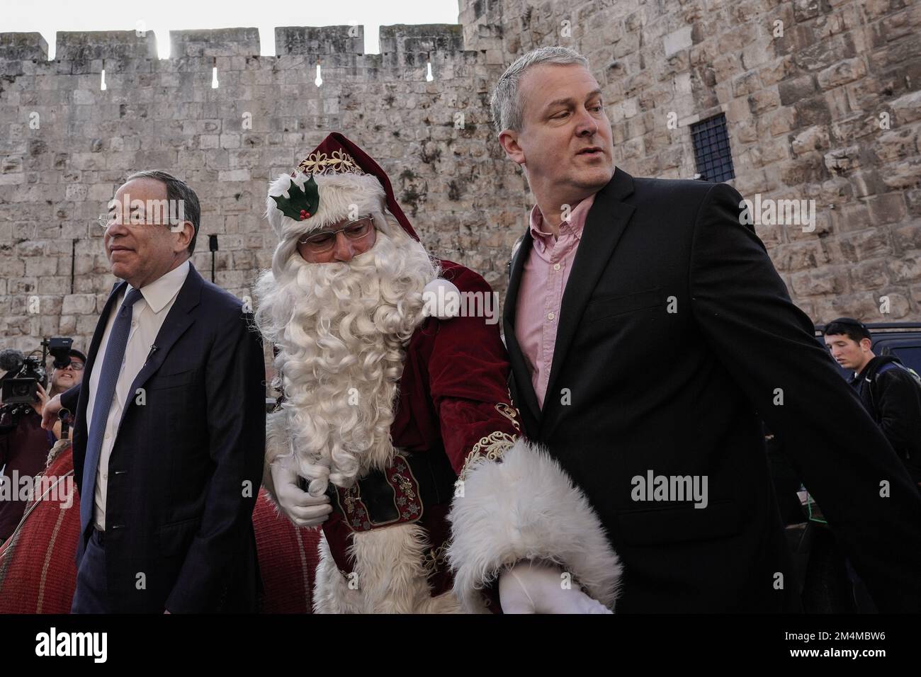 Jerusalem, Israel. 22nd Dec, 2022. U.S. Ambassador to Israel, THOMAS NIDES (L), and GEORGE NOLL (R), Chief Of The U.S. Office Of Palestinian Affairs, meet Santa Claus, portrayed by ISSA KASSISSIEH, at the Old City's Jaffa Gate. Credit: Nir Alon/Alamy Live News Stock Photo