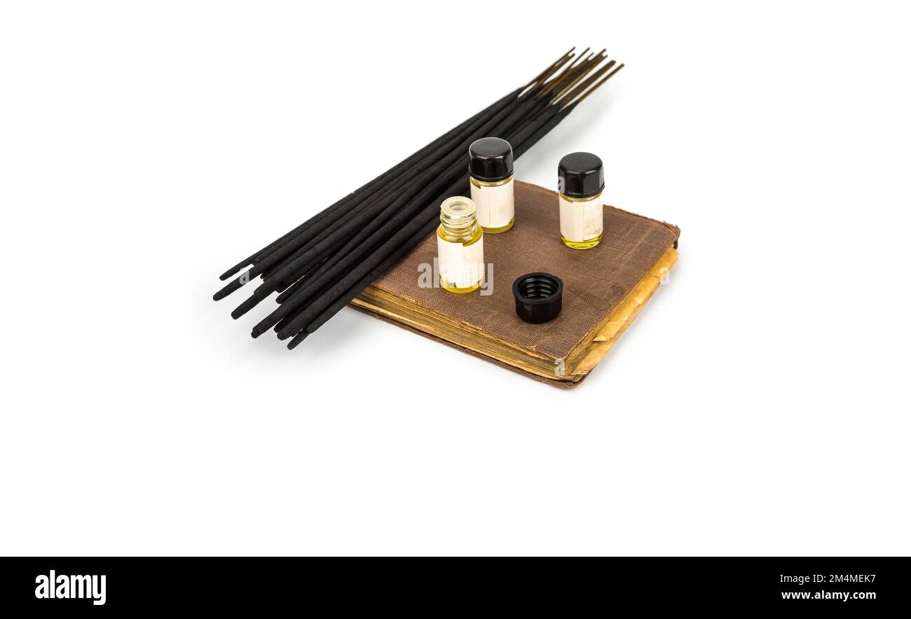 Incense sticks on a vintage book with fragrance bottles Stock Photo Alamy