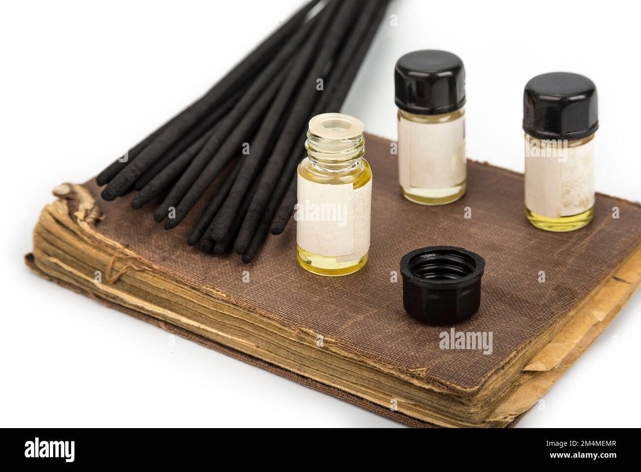 Incense sticks on a vintage book with fragrance bottles Stock Photo Alamy