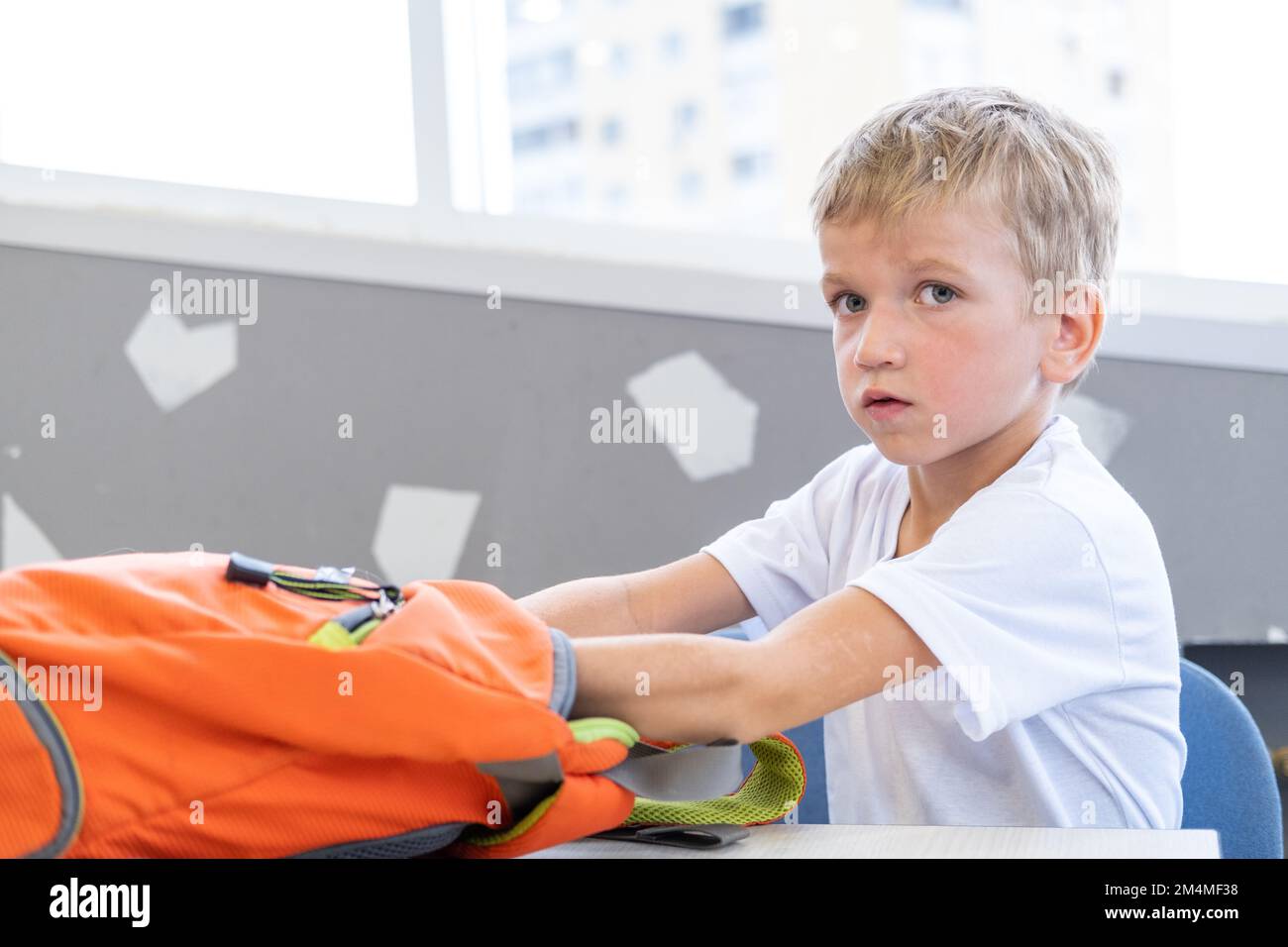 mom and the boy are packing a backpack for school, school