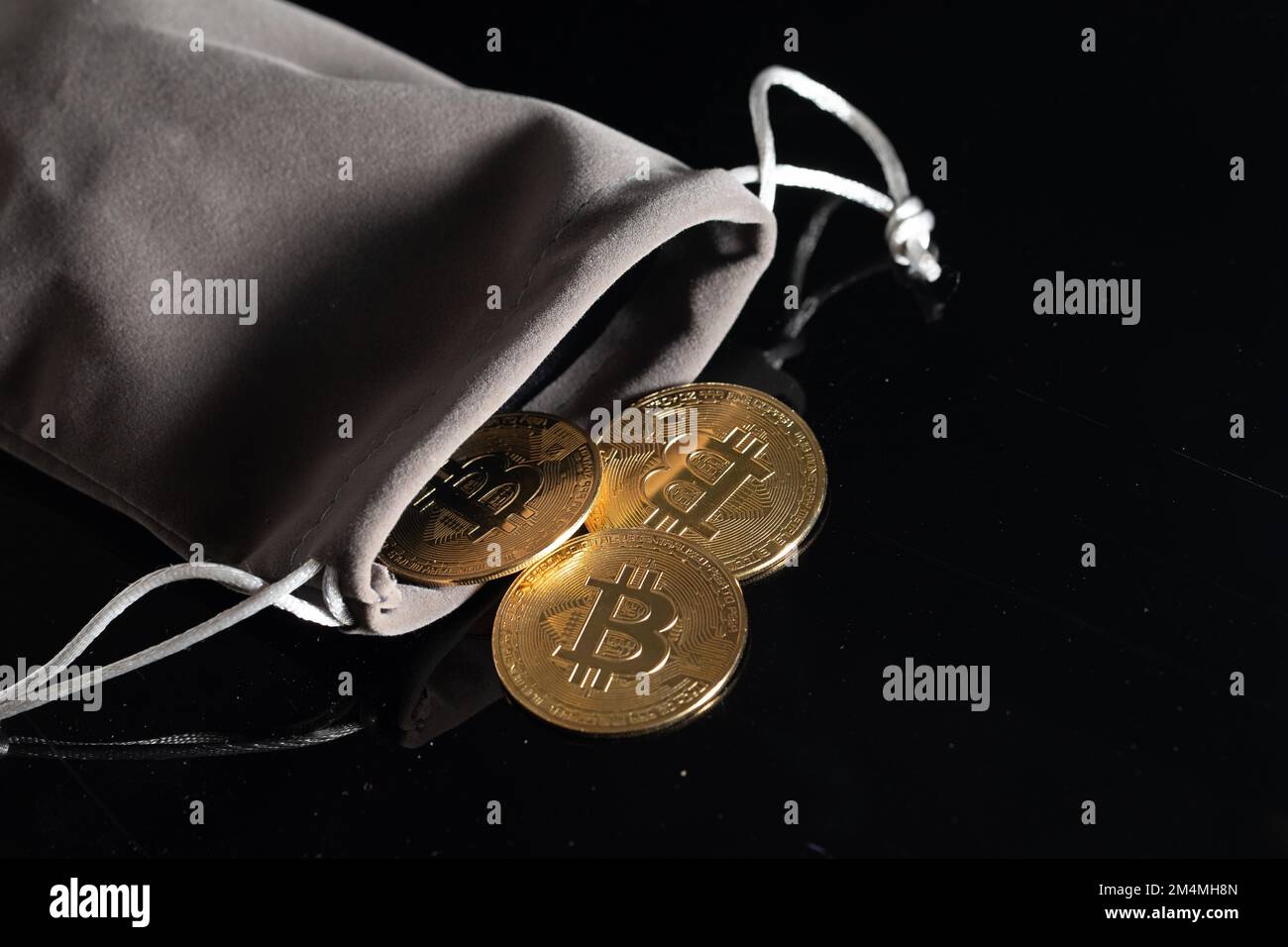 Close up Bitcoins in pouch wallet. Gold crypto coins on black table isolated background Blockchain and financial technology concept Stock Photo