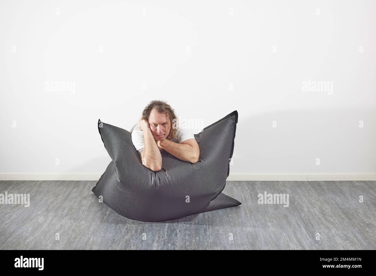 Man on beanbag in relaxing pose Stock Photo