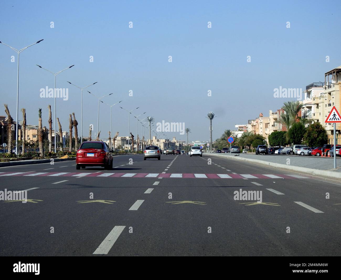 Cairo, Egypt, December 21 2022: Pedestrian crossing area on a highway road axis in Egypt with instructive paint on the asphalt and a road sign to inst Stock Photo