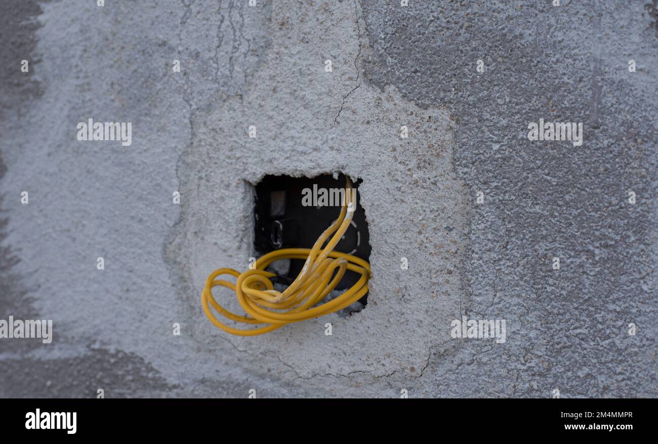 3 electric wires laying out from the concrete wall Stock Photo Alamy