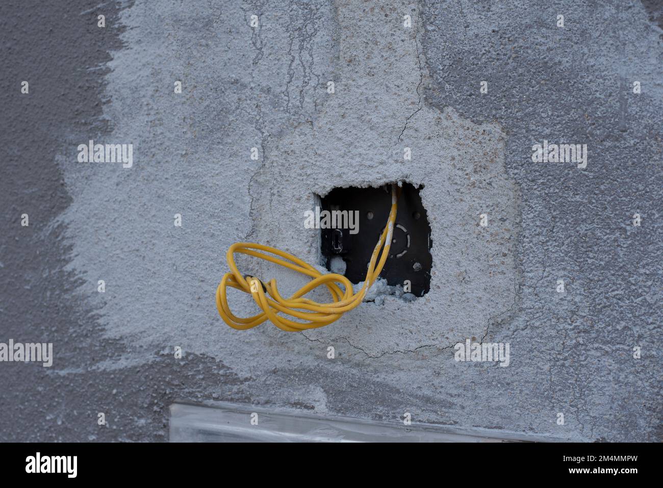 3 electric wires laying out from the concrete wall Stock Photo Alamy