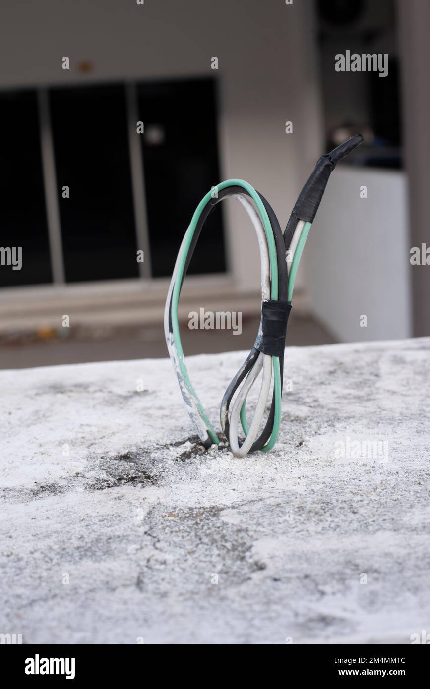 3 electric wires laying out from the concrete wall Stock Photo Alamy